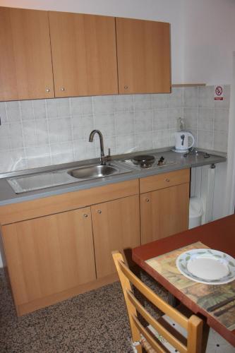 een keuken met een wastafel en een tafel met een bord bij Apartment Dragun in Pula