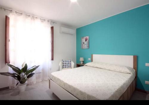 sypialnia z łóżkiem i niebieską ścianą w obiekcie Rainbow w mieście Castellammare del Golfo