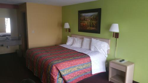 a hotel room with a bed with a colorful blanket at ECONOMY INN & SUITES in Harrisburg