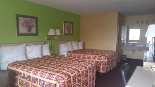 a hotel room with two beds and green walls at ECONOMY INN & SUITES in Harrisburg