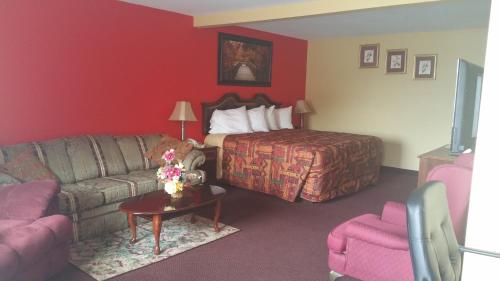 um quarto de hotel com uma cama e um sofá em ECONOMY INN & SUITES em Harrisburg