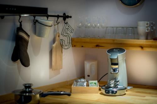 un mostrador de cocina con exprimidor y vasos en un estante en Guesthouse 115, en Valkenburg