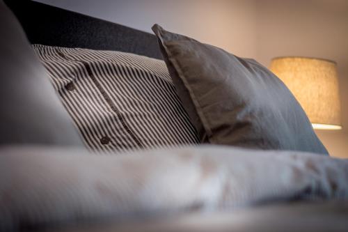 a pile of pillows on a bed with a lamp at Guesthouse 115 in Valkenburg
