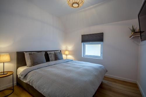 een slaapkamer met een groot bed en een raam bij Guesthouse 115 in Valkenburg