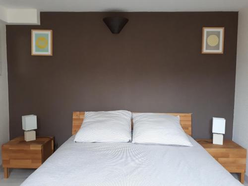 a bedroom with a white bed with two night stands at Le cosy plage in Ouistreham