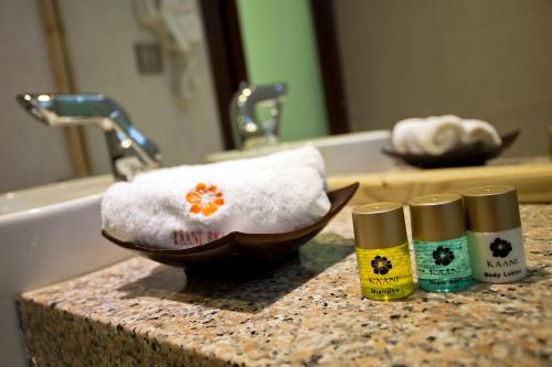 a bathroom counter with two bottles of soap and a towel at Kaani Beach Hotel in Maafushi