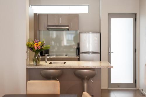 a kitchen with a counter with a vase of flowers on it at Boulcott Suites in Wellington