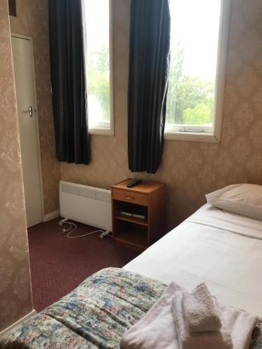 a bedroom with a bed and a window at Criterion Club Hotel in Alexandra
