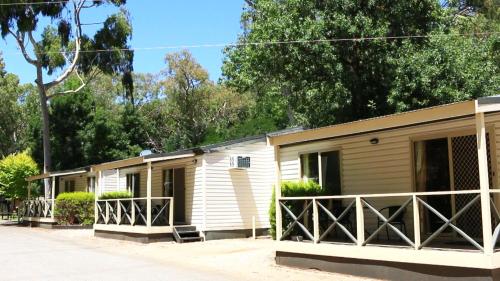a row of mobile homes with trees in the background at Adelaide Brownhill Creek Tourist Park in Adelaide