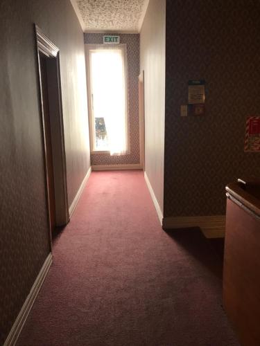 an empty hallway with a window in a building at Criterion Club Hotel in Alexandra