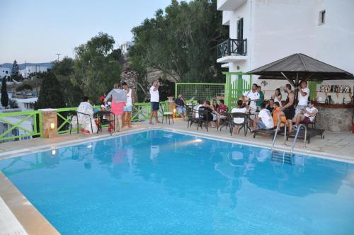 un grupo de personas sentadas alrededor de una piscina en Nefeli rooms Ios, en Ios Chora
