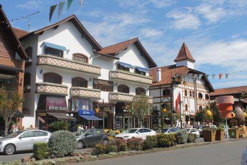 un edificio con coches estacionados en un estacionamiento en Acácia Negra - A Jóia do Centro, en Gramado