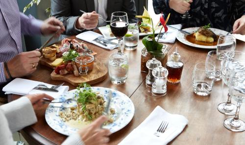a group of people sitting around a table with plates of food at The Belmore in Sale
