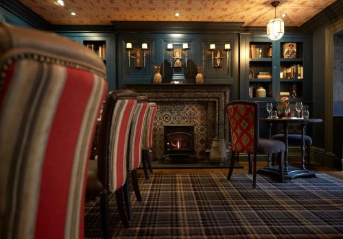 a living room with a fireplace with chairs and a table at The Belmore in Sale