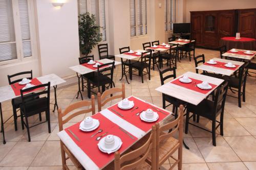 une salle à manger avec des tables, des chaises et des serviettes rouges dans l'établissement Trocadero, à Nice