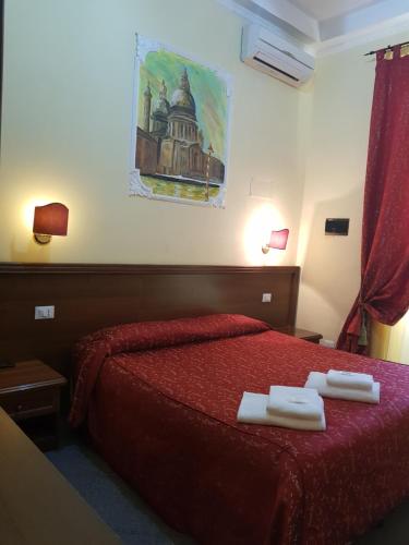 a hotel room with a red bed with two towels on it at B&B Rudy Center in Rome