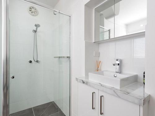 a white bathroom with a sink and a shower at Understated Elegance Affordable Luxury in Albury