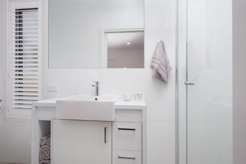 a white bathroom with a sink and a shower at Albury Yalandra Apartment 4 in Albury