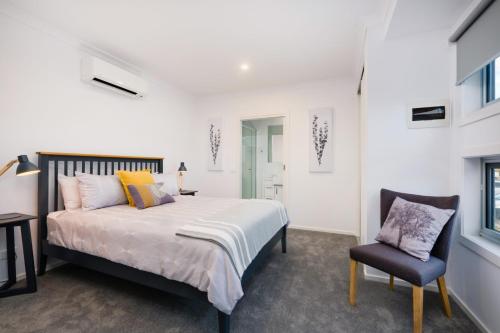 a bedroom with a bed and a chair at Albury Yalandra Apartment 4 in Albury