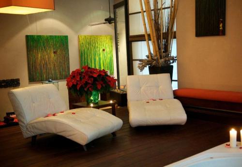 two white chairs in a room with flowers and candles at Executive Hotel Cosmopolitan Toronto in Toronto