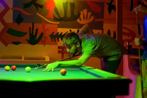 a man playing billiard in a pool table at Divanga Hostel and Diving in Taganga