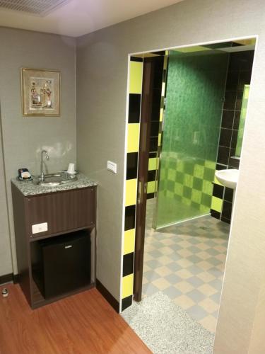 a bathroom with a sink and a shower at Klai Hotel in Kaohsiung