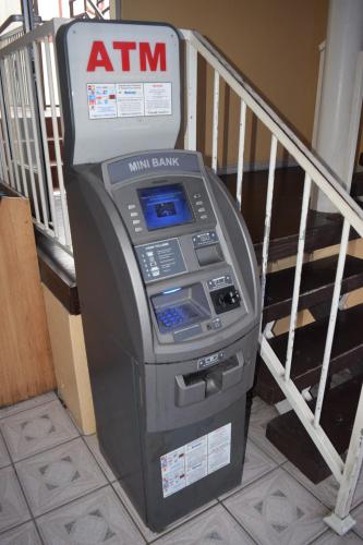 a atm machine sitting next to a stair railing at Deluxe Inn Hawthorne/ LAX in Hawthorne