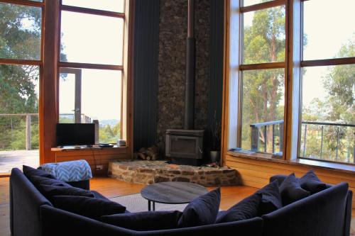 uma sala de estar com sofás e uma lareira com janelas em Peppermint Ridge Retreat em Woodbridge