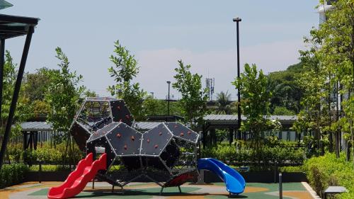 a playground with an umbrella and two slides at Oasis Condominium in Ipoh