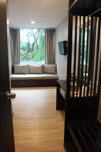 a living room with a couch and a window at YWCA Hotel Bangkok in Bangkok