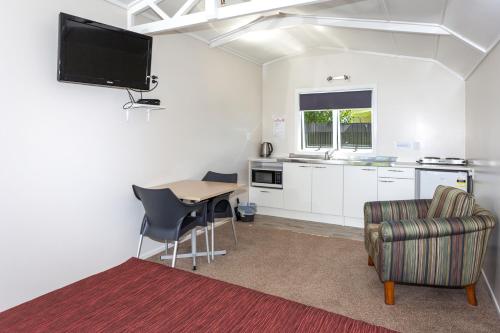 a kitchen and dining room with a table and chairs at Harbourside Holiday Park in Whitianga