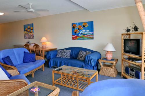 a living room with blue couches and a tv at Bright & comfortable in quiet location in Sunshine Beach