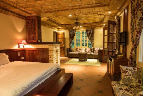 a bedroom with a bed and a living room at Sapa Garden Bed and Breakfast in Sa Pa