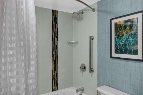 a bathroom with a shower and a white toilet at Hyatt Place Lakeland Center in Lakeland