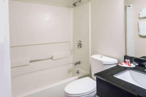 a white bathroom with a toilet and a sink at Super 8 by Wyndham Munfordville KY in Munfordville