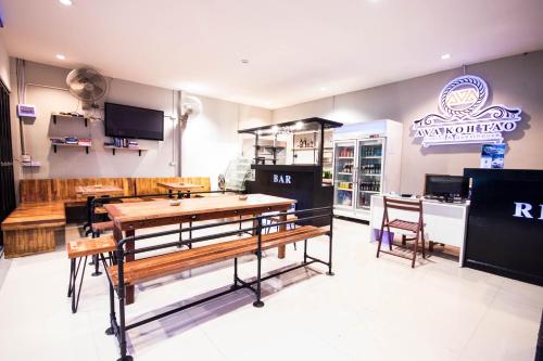 a restaurant with benches and tables in a room at AVA Boutique Guesthouse in Koh Tao