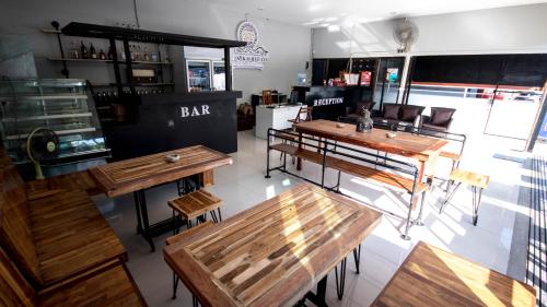 a restaurant with wooden tables and chairs and a bar at AVA Boutique Guesthouse in Koh Tao