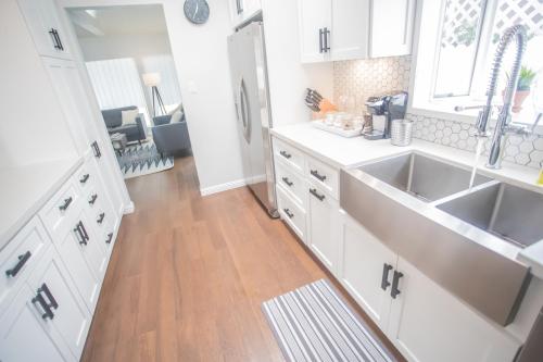 a kitchen with white cabinets and a sink at Enchanting Sherman Oaks Home With Pool permit #HSR two one zero zero 2605 in Sherman Oaks