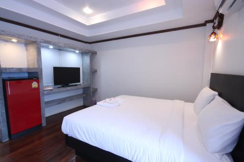 a bedroom with a white bed and a tv at AVA Boutique Guesthouse in Koh Tao