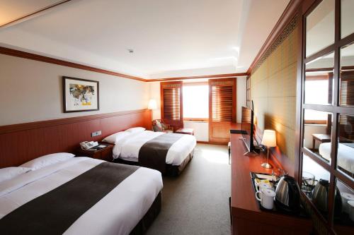 Postel nebo postele na pokoji v ubytování Commodore Hotel Gyeongju
