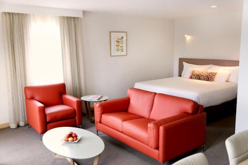 a hotel room with a bed and two chairs at Salamanca Inn in Hobart