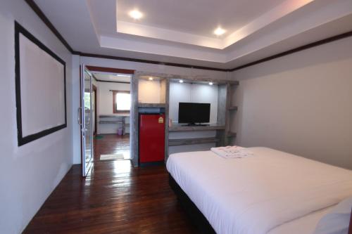 a bedroom with a white bed and a television at AVA Boutique Guesthouse in Koh Tao