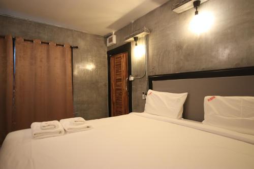a bedroom with a bed with two towels on it at AVA Boutique Guesthouse in Koh Tao