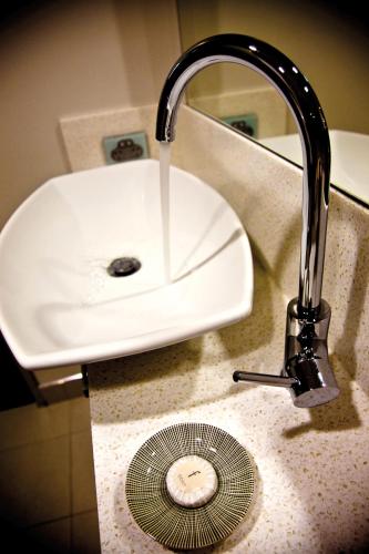 a white sink with a faucet and a drain at Salamanca Inn in Hobart
