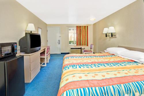 Habitación de hotel con cama y TV de pantalla plana. en Knights Inn Jacksonville at Dix Ellis Trail, en Jacksonville