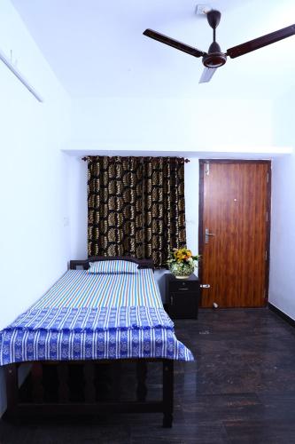 a bedroom with a bed and a ceiling fan at CBR Ayurhealth in Kannur