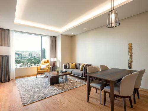 a living room with a table and a couch at Grand Mercure Ambassador Hotel and Residences Seoul Yongsan in Seoul