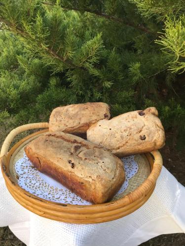 three loaves of bread in a basket on a table at Farmstay Marianówka u Tesi in Giby