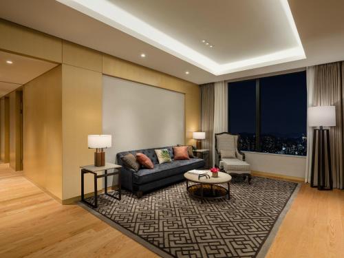 a living room with a couch and a table at Grand Mercure Ambassador Hotel and Residences Seoul Yongsan in Seoul