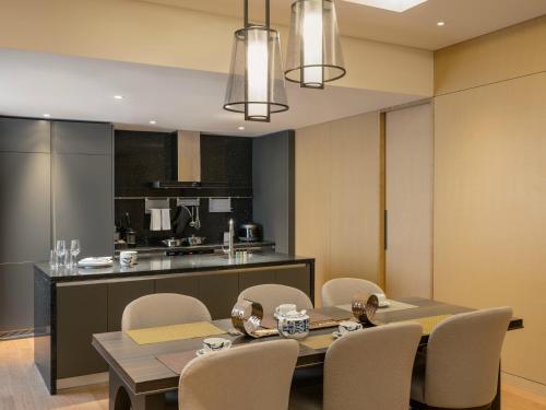 a dining room with a table and chairs and a kitchen at Grand Mercure Ambassador Hotel and Residences Seoul Yongsan in Seoul